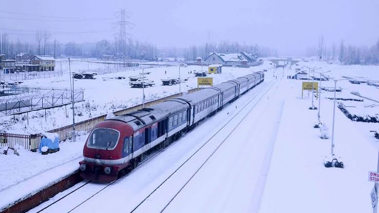 Train running across fields covered with snow in Kashmir valley